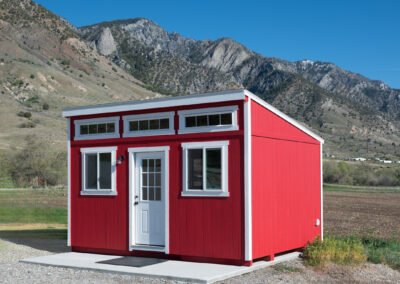 Red lean-to style shed with white trim