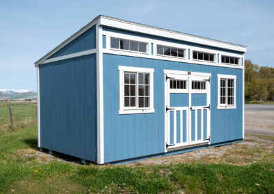 Blue lean-to style shed with white trim